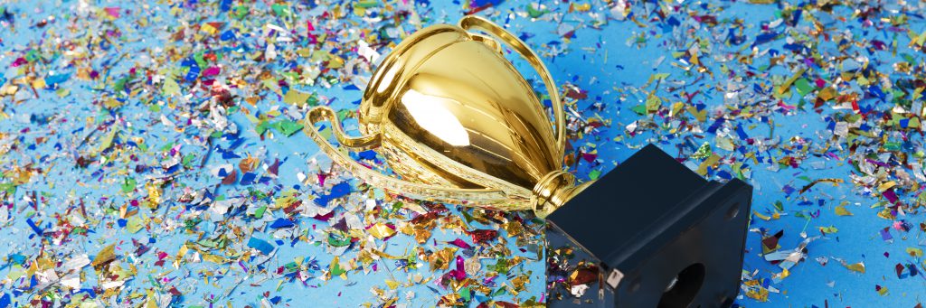 Gold trophy on a confetti background